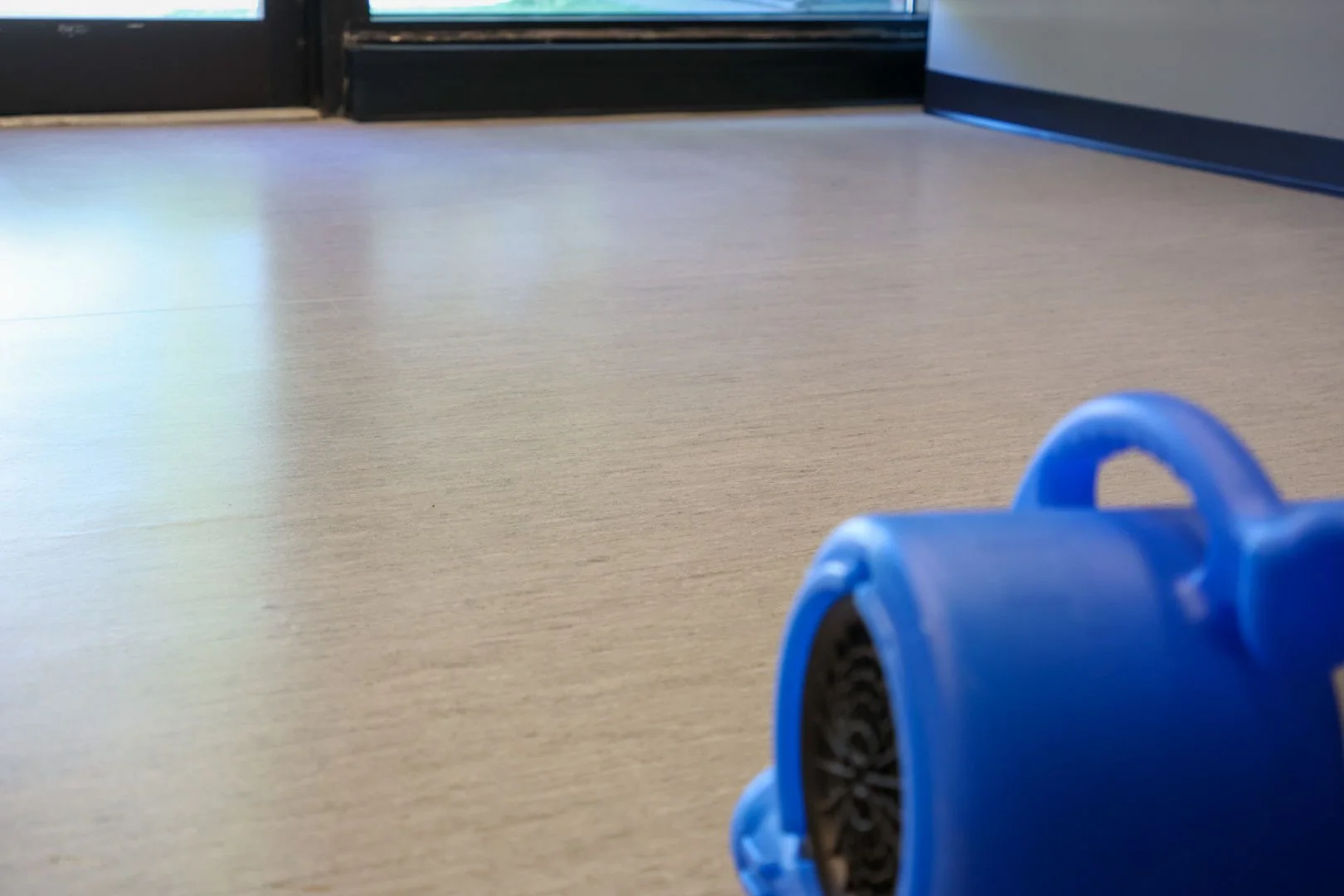 Professional air mover drying a freshly cleaned commercial floor