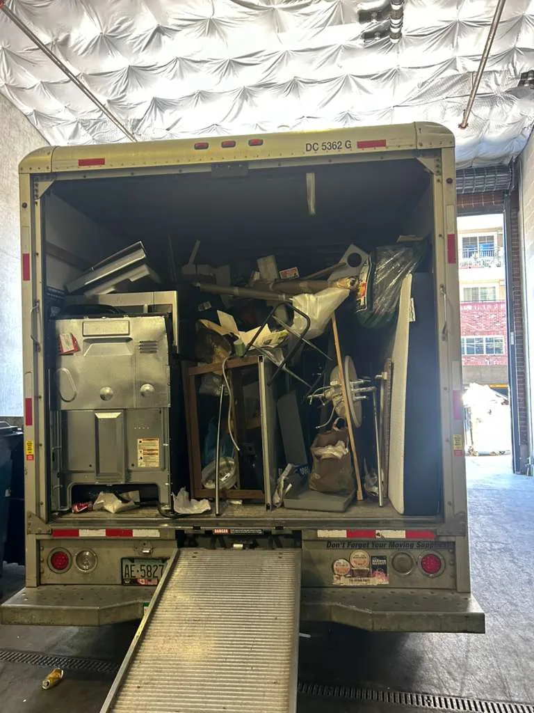 Junk removal truck loaded with furniture, appliances and bulky items after a property cleanout