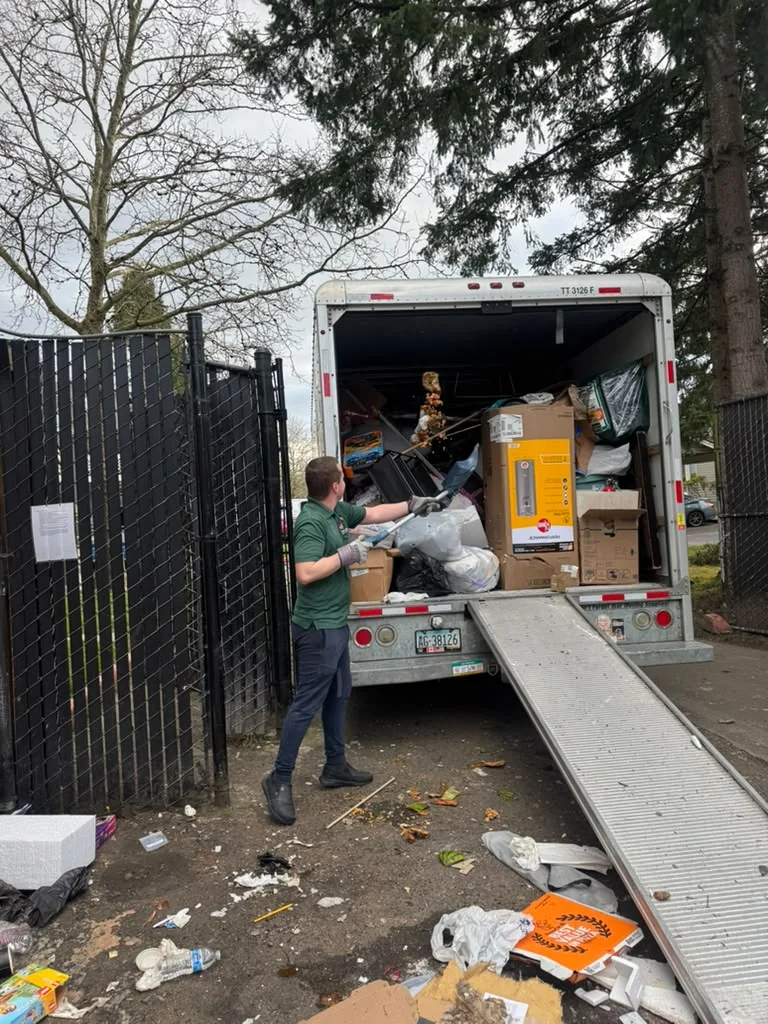 Junk removal truck being loaded during a property cleanout