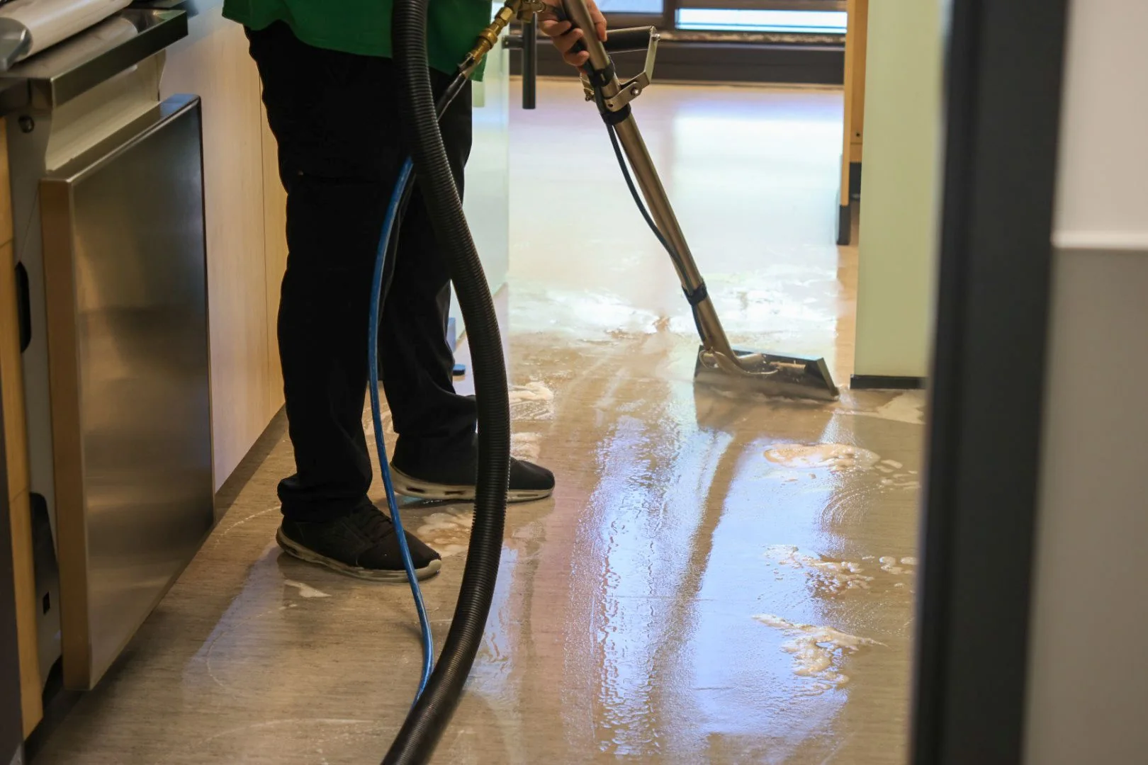 Technician extracting water while cleaning a commercial floor
